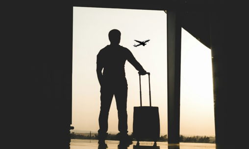 silhouette of man holding luggage inside airport